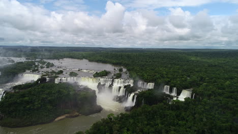 Panoramic-wide-view-of-Iguazu-falls-cascading-in-crescent-shape-in-lush-forest