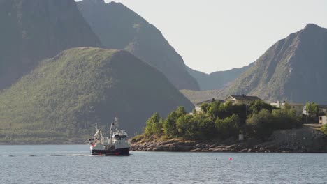 Barco-De-Pesca-Tirando-Red-En-La-Isla-De-Husoya,-Nordland,-Noruega