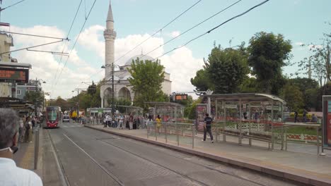 On-a-partly-cloudy-day-during-daylight-hours,-a-tram-approaches-the-Sultanahmet-tram-stop-in-Istanbul