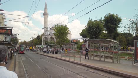 En-Un-Día-Parcialmente-Nublado-Durante-El-Día,-Un-Tranvía-Se-Acerca-A-La-Parada-De-Tranvía-De-Sultanahmet-En-Estambul