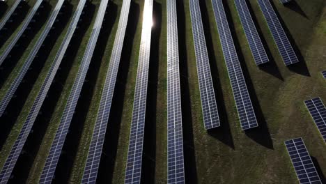 Side-drone-shot-of-the-solar-panels-field-reflecting-sun-rays