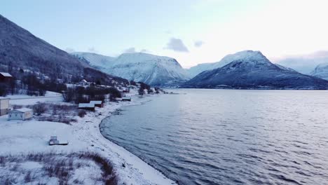 Rote-Häuser-In-Norwegen,-Bedeckt-Mit-Schnee-An-Den-Fjorden