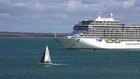 Segelboot-Vorbei-An-Verankertem-Kreuzfahrtschiff-In-Dunmore,-East-Waterford,-Irland