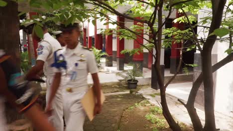Four-Seafaring-or-Maritime-Vocational-School-students-or-taruna-walk-with-laptops-to-the-park-to-study-outdoors-or-take-classes-in-the-school-garden