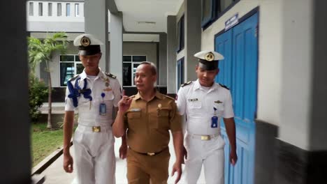 Two-teenage-vocational-school-students-or-taruna-and-their-teacher-were-walking-talking-in-front-of-the-class