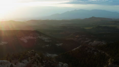 Aerial-view-overlooking-layers-of-wilderness-and-mountains,-sunset-in-Utah,-USA