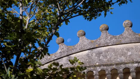 Slow-revealing-shot-of-crown-like-design-on-a-chateau-with-the-moon-in-the-sky