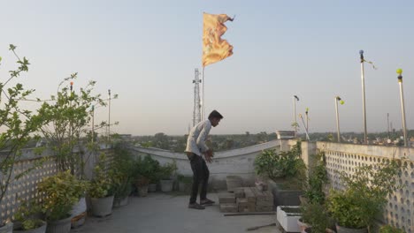 Junger-Mann-Auf-Dem-Dach-Unter-Religiöser-Und-Kultureller-Hinduistischer-Flagge