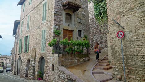 Eine-Person-Geht-Auf-Einer-Schmalen-Straße-Mit-Steinbauten-In-Der-Antiken-Stadt-Assisi-In-Umbrien,-Italien