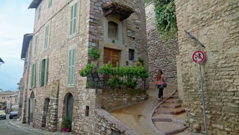 La-Persona-Camina-Por-La-Calle-Estrecha-Con-Estructuras-De-Piedra-En-La-Antigua-Ciudad-De-Asís-En-Umbría,-Italia