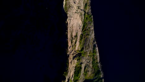 Aerial-Top-down-shot-with-steep-mountain-ridge-from-the-Peak-Hesten-on-Senja-Island-during-midnight-sun-late-evening