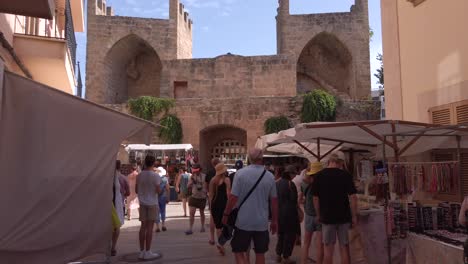 Gate-of-the-city-walls-of-Alcudia-seen-from-inside-with-Souvenirs-shops-on-the-street
