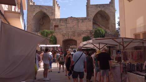 Tor-Der-Stadtmauer-Von-Alcudia-Von-Innen-Gesehen-Mit-Souvenirläden-Auf-Der-Straße