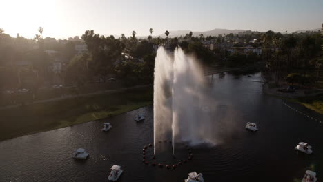 Una-Toma-Aérea-De-Rayos-De-Luz-Cinematográficos-Que-Atraviesan-La-Fuente-Del-Parque-Echo