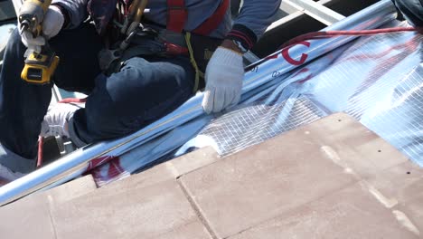 Asian-Worker-Doing-Roof-Tiles-Installation,-Cutting,-Measuring-Process,-Close-Up