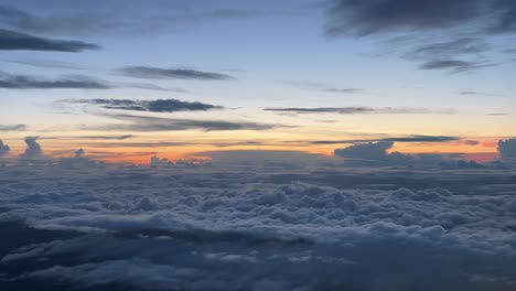 View-of-sunset-while-flying-above-the-clouds,-POV-shot-of-an-airplane-flying