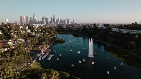 Eine-Filmische-Drohnenaufnahme-Des-Echo-Park-Lake-Mit-Der-Innenstadt-Von-Los-Angeles-Im-Hintergrund
