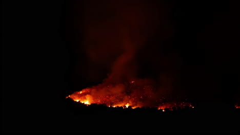 Zeitraffer-Eines-Schwelenden-Waldbrandes,-Der-In-Der-Nächtlichen-Dunkelheit-Leuchtet-Und-Sich-Beruhigt