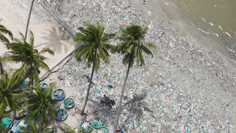 Aerial-top-down-of-tropical-beach-covered-with-plastic-bottle-bag-and-waste-garbage-palm-tree-south-east-asia-enviroment-agenda-2030-concept