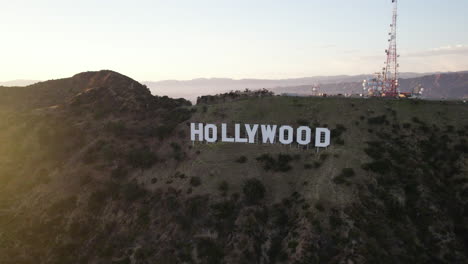 Eine-Luftaufnahme-Des-Hollywood-Schriftzugs-Zur-Goldenen-Stunde-Mit-Einem-Leuchtsignal