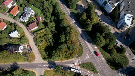 Aerial-top-down-shot-of-driving-bus-on-road-and-polish-neighborhood-during-sunny-day-in-Gdynia-City