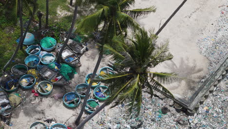 Tropical-beach-with-palms-covered-in-rubbish,-aerial-top-down-view