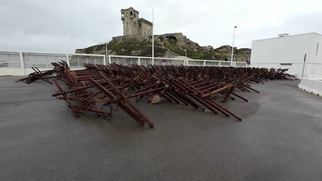 A-Smooth-Shot-Of-A-Park-In-Spain-With-Ancient-Grappling-Hooks-And-An-Old-Building