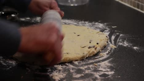 Close-up-shot-of-a-baker-using-a-rolling-pin-to-roll-out-the-scone-mix-evenly