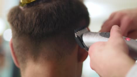 Handheld-view-of-man-has-cutting-hair-at-the-hairdresser