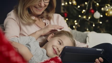 Video-of-grandma-with-granddaughter-watching-cartoons-on-the-tablet