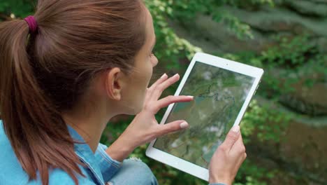 Woman-using-a-tablet-during-hiking-trip