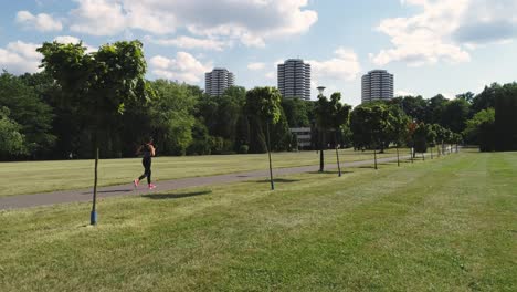 Drone-view-of-young-woman-running-in-the-park,-Katowice,-Poland