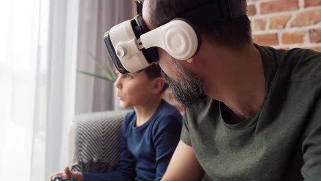 Video-Von-Vater,-Der-Eine-VR-Brille-Trägt-Und-Mit-Seinem-Sohn-Spielt