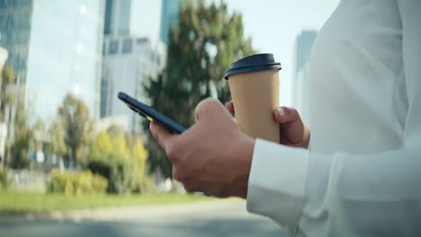 Close-up-video-of-businesswoman-with-coffee-and-phone-outdoors
