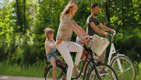 Video-Einer-Verspielten-Familie,-Die-Sich-Auf-Einem-Fahrrad-Im-Wald-Vergnügt