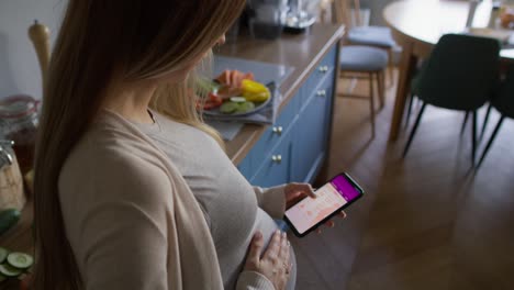 Schwangere-Frau-Nutzt-Mobile-App-Auf-Dem-Smartphone.