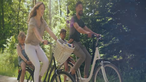 Video-De-Una-Familia-Juguetona-Andando-En-Bicicleta-Por-El-Bosque.