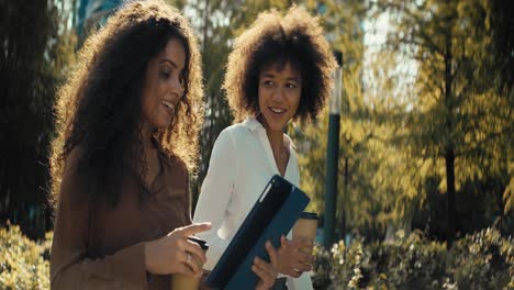 Video-Von-Geschäftsfrauen,-Die-Draußen-Mit-Einem-Digitalen-Tablet-Spazieren-Gehen-Und-Diskutieren