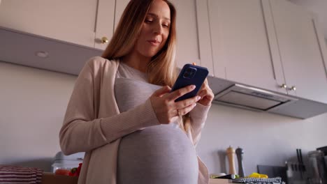 Pregnant-woman-eating-healthy-food-and-using-mobile-phone