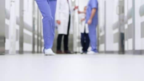 Part-of-doctors-walking-through-corridor-in-hospital