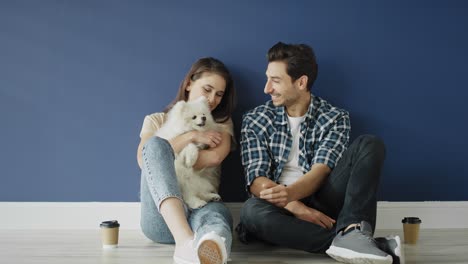 Zoom-out-video-of-couple-with-dog-in-empty-house.
