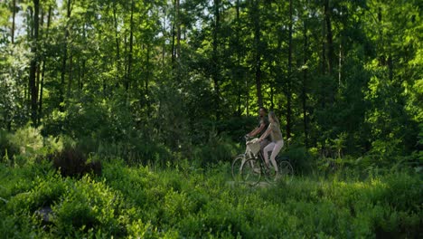 Rückansicht-Eines-Paares,-Das-Im-Wald-Fahrrad-Fährt