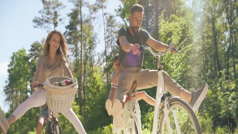 Vista-Inferior-De-Una-Familia-Juguetona-Montando-Bicicletas-En-El-Bosque