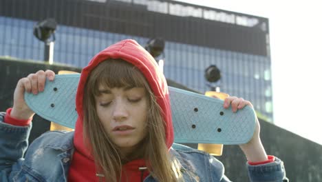 Handheld-view-of-young-woman-with-skateboard-in-the-city