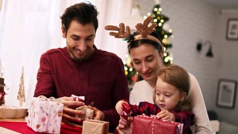 Handansicht-Einer-Familie-Mit-Baby,-Die-Weihnachtsgeschenke-öffnet