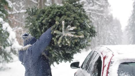 Un-Hombre-Con-Un-Padre-Mayor-Empacando-Un-árbol-De-Navidad-En-El-Auto