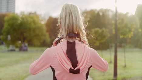 Handheld-view-of-jogging-woman-listening-to-music