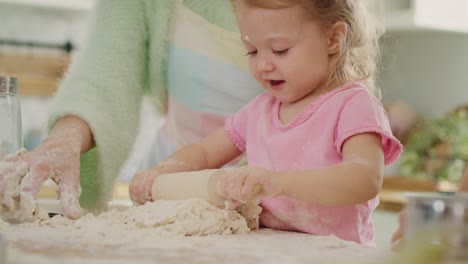 Handheld-view-of-little-girl-rolling-dough-for-cookies