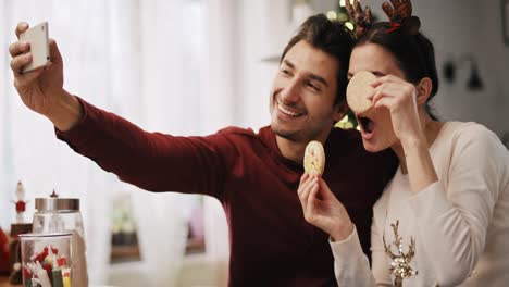 Handheld-Ansicht-Eines-Verspielten-Paares,-Das-In-Der-Weihnachtszeit-Ein-Selfie-Macht