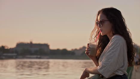 Mujer-Joven-Bebiendo-Café-Helado-En-La-Ciudad